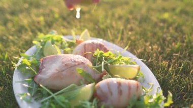 Dumanlı kızarmış kalamar limon suyuyla yağmurlama ve çim dışında ızgara ve Barbekü, deniz ürünleri yemek yapma açık ateş üzerinde pişirme günbatımı ışıkta taze yeşillikleri ile plaka üzerinde yatıyor