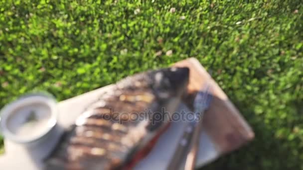 La carpa se ha asado en el fuego abierto con tomates y verduras y se encuentra en el tablero con salsa lista para comer, pescado a la parrilla, parrilla y barbacoa, cocina al aire libre, comidas de verano, comida campestre — Vídeos de Stock