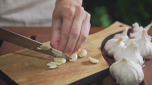 Küchenchef zerfetzt Knoblauch auf dem Holzbrett am Grill, macht den Salat, pflanzliche Mahlzeit, Vitamine in der täglichen Nahrung, Kochen im Freien — Stockvideo