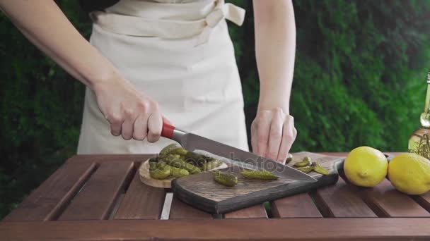 Chef tritura pepinos en vinagre en el tablero de madera, hacer ensalada, comida vegetal, vitaminas en la comida diaria, cocinar al aire libre — Vídeo de stock