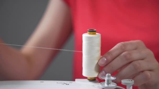 Naaister unwounds draad van de spoel en begint naaimachine met wollen draad en vilt, confectie-industrie, handgemaakt, naaien kleding en ondergoed — Stockvideo