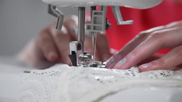 Портной шьет нижнее белье на швейной машинке, нитки и кружева, нижнее белье ручной работы и одежду, швейную машинку на рабочем процессе, работает в швейной мастерской — стоковое видео