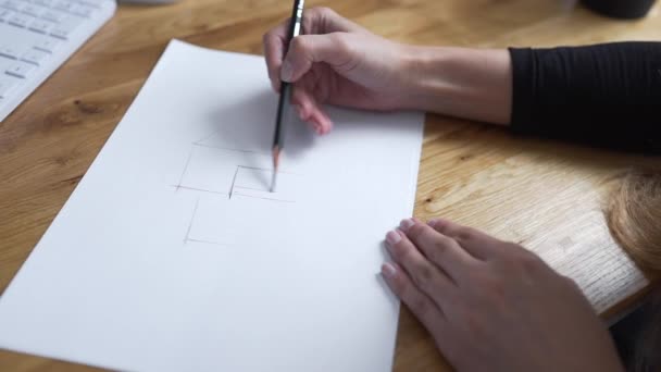 Художник рисует карандашом, дизайнер рисует чертеж, женщина рисует линии, архитектор начинает рисовать проект на бумаге — стоковое видео