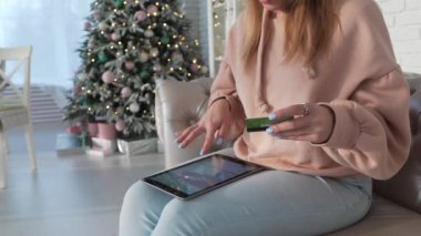 Kadın kanepede oturuyor ve onun kredi kartı bilgileri, online ödeme, online alışveriş girerek tablet ile internet alışveriş yapar, kız koltukta oturur ve ürünler online satın