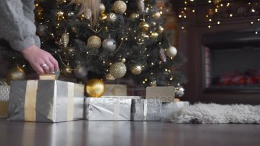 Kadının elleri ile kutuları koymak hediyeler Noel ağacı, parlak Noel ağacı, çelenk ve topları altında yeni yıl, yeni yıl arifesinde Noel hazırlıkları, sunar