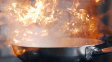 Yemek setleri yangın flambe, ile pişirme için yangın, kızartma ve ızgara, soba üzerinde tava sıcak, ağır çekim 240 kare / saniye içinde ateş