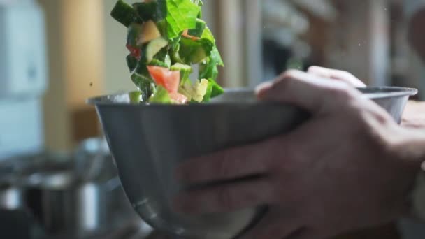 O cozinheiro mistura salada com legumes, jogando-o em câmera lenta, cozinhar em câmera lenta, refeições vegetarianas, 240 quadros por segundo — Vídeo de Stock