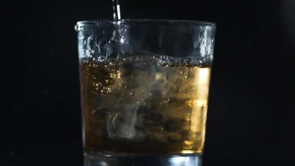 Алкоголь наливают в стекло кубиками льда в замедленной съемке, бармен делает напитки, 240 кадров в секунду — стоковое видео