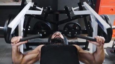 Güçlü adam fitness kulübünde spor salonu, güç egzersizleri simülatörleri, atlet kaslara pompalıyor, sakallı beyaz adam kas pompalama