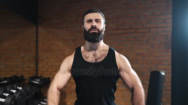 Homme fort est pompage muscles à la salle de gym, exercices de puissance avec haltères, athlète au club de fitness, homme caucasien avec barbe est pompage biceps — Video