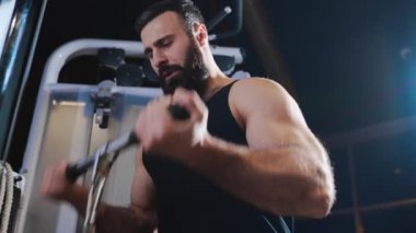 Güçlü adam fitness kulübünde spor salonu, güç egzersizleri simülatörleri, atlet kaslara pompalıyor, sakallı beyaz adam kas pompalama