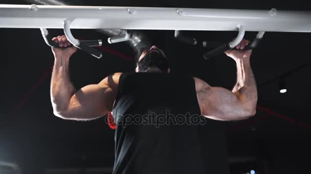 Silný muž pumpuje svaly v posilovně, sílu cvičení na simulátoru, shybů na vodorovný pruh, sportovec na fitness klubu, Kavkazský muž s plnovousem pumpuje svaly — Stock video