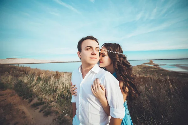 Aşık genç çift göl kenarında dinlenme birlikte ve Dağları, güzel beyaz kadın ve adam düştü sevgi, şefkat ve hugs, güzel arka planı düz çift