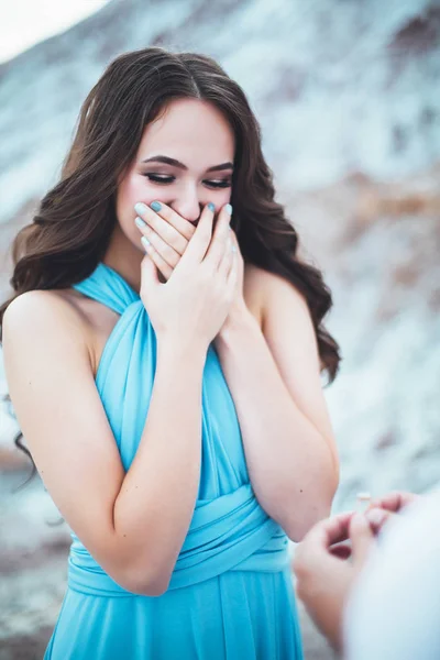 The guy makes a marriage proposal to his girlfriend, marriage proposal agains the mountains, woman happy because of unexpected marriage proposal with ring from her boyfriend — Stock Photo, Image