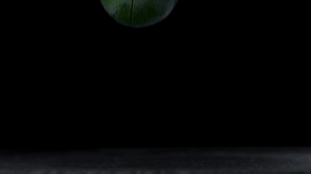 Зеленый авокадо падает и распадается на 2 половинки в замедленной съемке, еда в супер замедленной съемке, 240 кадров в секунду — стоковое видео
