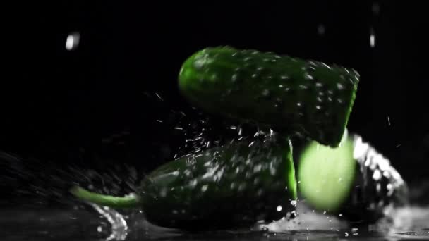 Los pepinos verdes caen y se dividen en mitades en cámara lenta, comida en cámara súper lenta, 240 fotogramas por segundo, verduras frescas y agua — Vídeo de stock