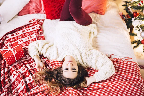 Kazak yalan christmase, parlak Noel ağacı, çelenk ve topları için mevcut hediye ile kanepede güzel kadın, yeni yıl hediyeleri Noel hazırlıkları, yeni yıl arifesinde