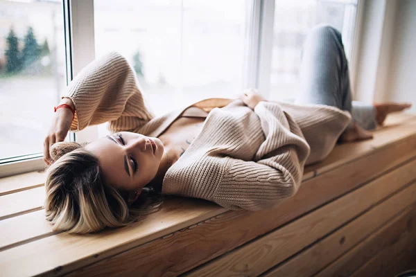 Rahat İskandinav interrior güzel beyaz şık kadın evde oturur büyük pencere, güzel kız, moda portre, şık kadın portresi