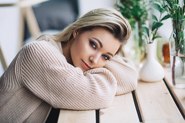 Beautiful white stylish woman in cozy scandinavian interrior sits at home near the big window, portrait of the beautiful girl, fashion portraits, stylish woman — Stock Photo, Image