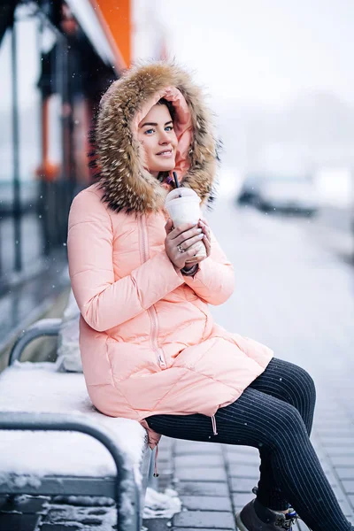 Sonriendo mujer bonita feliz en abrigo de invierno caliente al aire libre disfruta de café caliente, guantes y capucha, tiempo de niebla —  Fotos de Stock