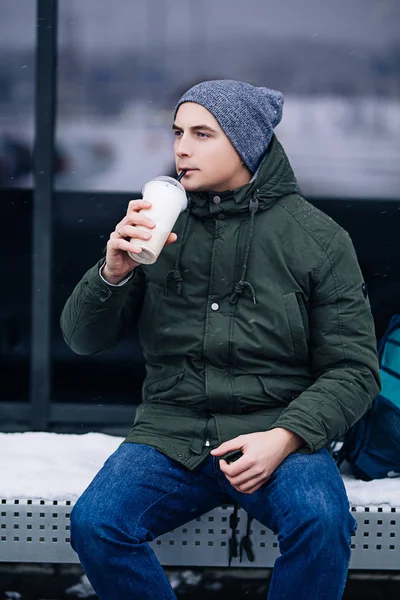 Beyaz adam sıcak kış ceket açık havada sıcak kahve, suni kap, hava, sıcak kahve kar yağışı sahiptir