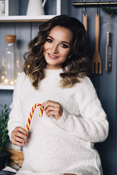 Kafkas hamile kadın ile telafi etmek ve sıcak beyaz kazaklı kıvırcık saçlı şeker, gelecekte anne, mutlu hamilelik, moda portre, şık gebelik portre tutar