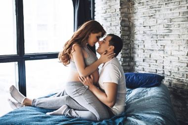 Mutlu gelecek anne bekliyor bebek için evli çift bekliyor bir çocuk, kırmızı uzun saç, güzellik gebeliğin, Aile çift yatak odasında olan hamile kadın için