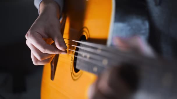 Гитарист играет гаммы и гаммы на акустической западной гитаре со стальными струнами по технике отбора пальцев, упражнениям и арпеджио, видео со звуком, щёлкает гитарой, музыкальным инструментом — стоковое видео