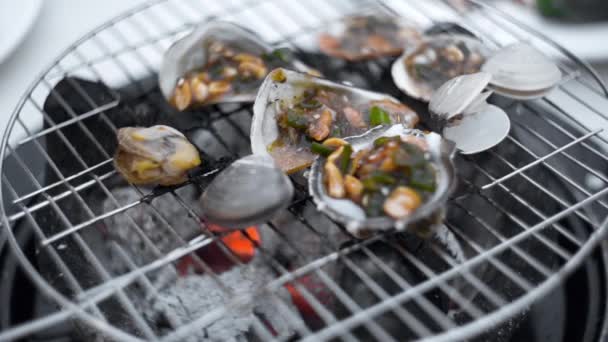 Mexilhões são assados no molho na fogueira aberta da grelha, cozinhando de marisco ao ar livre, churrasco de frutos do mar, grelhando a comida — Vídeo de Stock