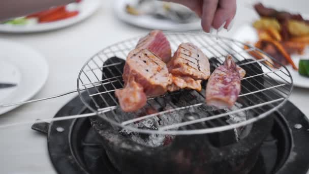 Pedaços de atum vermelho são assados na fogueira aberta da grelha, o cozinheiro polvilha peixe cozido por suco de limão, churrasco de frutos do mar, grelhando a comida. — Vídeo de Stock