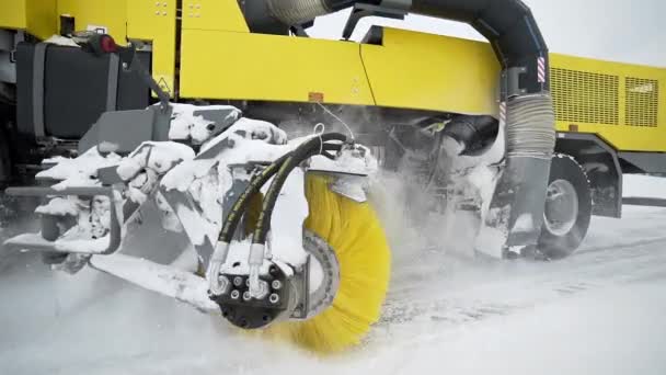 Maquinaria de ruedas pesadas elimina la nieve de la carretera con un gran cepillo giratorio masivo en el clima nevado, maquinaria especial para la limpieza de carreteras, la nieve y la eliminación de hielo, camión especializado — Vídeo de stock