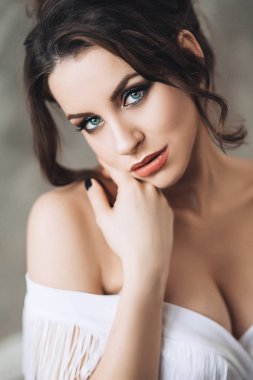 Beyaz Siyah saçlı, mavi gözlü ve beyaz elbiseli brest açılış derin yaka ile ayakta şehvetli kırmızı dudaklar ile güzel çekici seksi kadın portresi