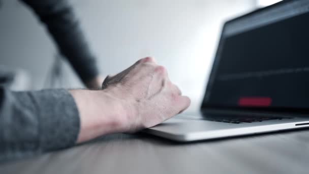 Ο άνθρωπος σε γκρι πουλόβερ σερφάρει στο internet με το laptop του και χρησιμοποιεί μαξιλάρι αφής, σύροντας το touchpad, επανδρώνει τα χέρια χρήση του φορητού υπολογιστή, εσωτερικη των χεριών με το σημειωματάριο, ψάχνει το διαδίκτυο, κοινωνικών μέσων μαζικής ενημέρωσης, e — Αρχείο Βίντεο