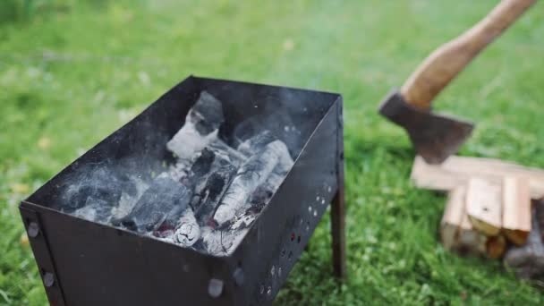 Fumar brasas calientes están en la parrilla al aire libre, barbacoa en el patio trasero, haciendo carbones rojos para la cocina en el fuego abierto, barbacoa de verano, madera y fuego — Vídeos de Stock