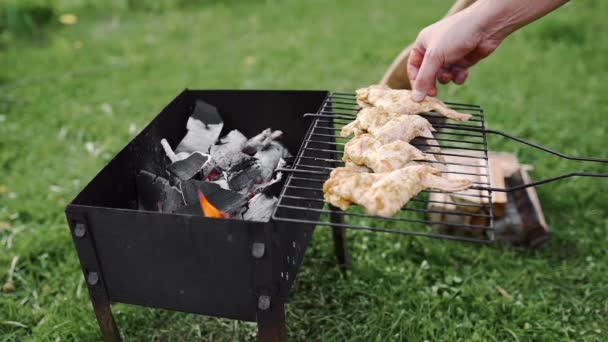 Chef hace barbacoa con alas de pollo en las brasas calientes de la parrilla al aire libre, barbacoa en el patio trasero — Vídeo de stock
