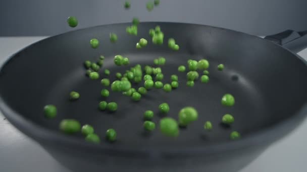 Los guisantes verdes caen en cámara lenta a la sartén, las verduras frescas están cayendo en 240 fps, cocinar la mezcla de verduras, comidas vegetarianas con frijoles, Full HD Prores 422 HQ — Vídeos de Stock