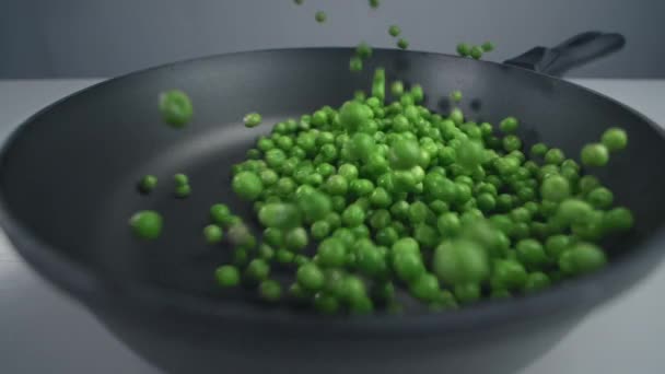 Los guisantes verdes se lanzan a la sartén en cámara lenta, las verduras frescas están cayendo en 240 fps, cocinar la mezcla de verduras, comidas vegetarianas con frijoles, Full HD Prores 422 HQ — Vídeos de Stock