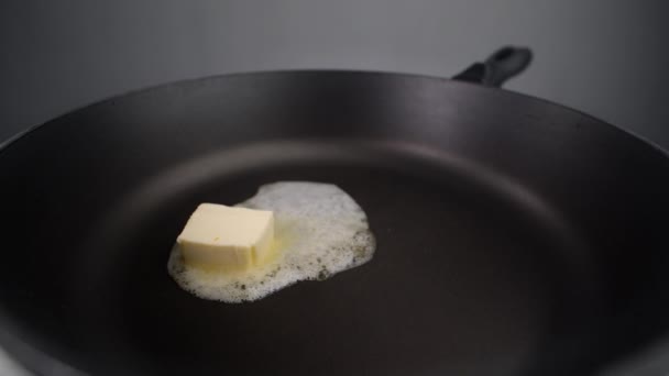 버터는 뜨거운 팬 위에서 느린 동작으로 녹아 가고 있습니다. 볶거나, 뜨거울 때먹을 수있는 음식이고, 우유 제품으로 요리할 수있습니다. — 비디오