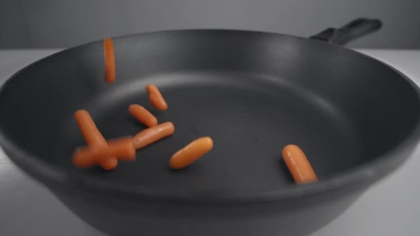 Маленькая морковь падает в замедленной съемке на сковороду, свежие овощи падают в 240 кадров в секунду, приготовление овощной смеси, вегетарианские блюда с морковью, Full HD Prores 422 HQ — стоковое видео