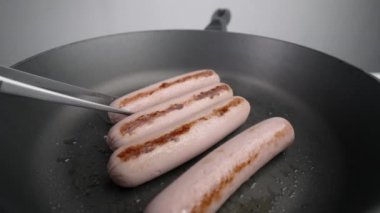 Şef sıcak tavada cımbızla kızarmış sosis pişirir, kızartma buluşması, mutfakta sosis pişirme, sağlıksız yemek, evde fast food, Full Hd 120fps Prores Hq
