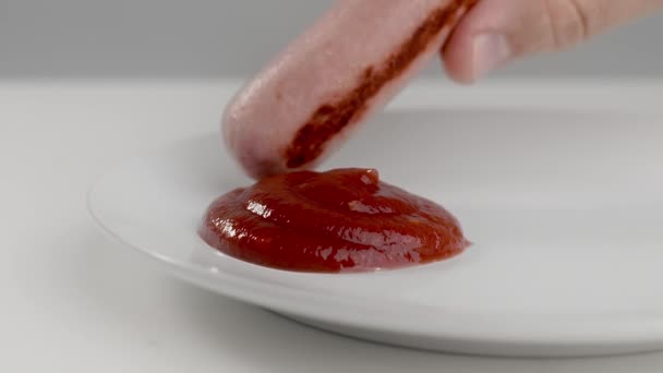 La salchicha se sumerge en ketchup en cámara lenta, ketchup de tomate con carne, salchicha en el plato con salsa picante, Full HD 120fps Prores HQ — Vídeo de stock