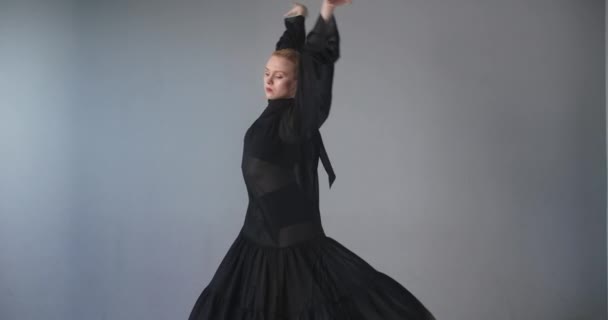 Ξανθιά ελκυστική χορεύτρια με μακιγιάζ σε μακρύ μαύρο φόρεμα κάνει ασκήσεις μπαλέτου και κόλπα, πρόβα μπαλέτου, μπαλαρίνα κάνει βήματα χορού στο κοστούμι στάδιο, μάθημα στούντιο χορού, 4k DCI 60p — Αρχείο Βίντεο