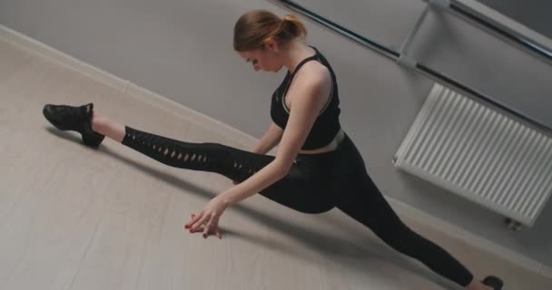 Attraktive junge Frau sitzt in Zeitlupe auf einem Seil in der Nähe der Ballettmaschine, flexible Frau macht akrobatische und plastische Übungen, Yoga und Stretching, 4k DCI 60p Prores 422 — Stockvideo