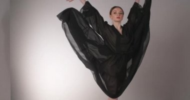 Uzun siyah elbiseli bayan dansçı bale egzersizleri ve numaralar yapıyor, bale provası yapıyor, balerin sahne kostümlü dans adımları atıyor, dans stüdyosu dersi, 4k DCI 60p Prores HQ