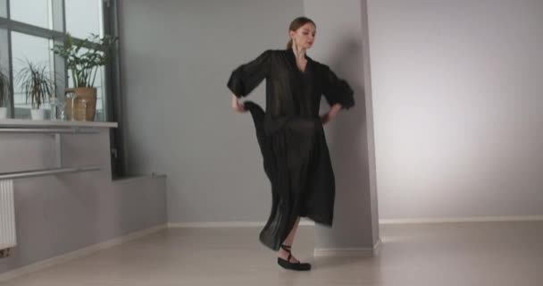 Ελκυστική χορεύτρια με μακιγιάζ σε μακρύ μαύρο φόρεμα άλματα σε αργή κίνηση, ασκήσεις μπαλέτου και κόλπα, πρόβα μπαλέτου, μπαλαρίνα κάνει βήματα χορού στο κοστούμι σκηνή, μάθημα στούντιο χορού, 4k — Αρχείο Βίντεο