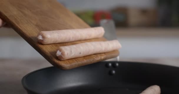 Råa korvar faller från träbrädan till den varma grillpannan i slow motion, matlagning varmkorv, rostning av köttprodukter, kokt kyckling, 4k 60p 10 bit Prores HQ 422 — Stockvideo