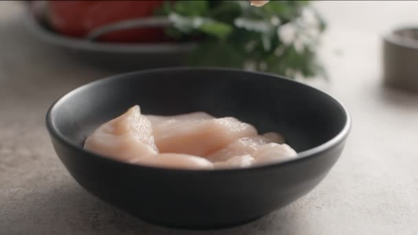 Morceaux de poulet cru tombe au ralenti dans le bol, la cuisson des pépites de poulet, repas de régime, saler le plat, table vidéo ralenti, Full HD 240fps 10 bits Prores HQ — Video