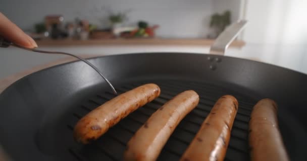 Salsiccia arrosto viene portato via dalla padella calda con la forchetta, salsicce alla griglia, cottura hot dog con prodotti a base di carne, pollo cotto, 4k 60p 10 bit Prores HQ 422 — Video Stock