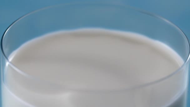 De druppel melk druppelt op het volle glas in slow motion, macro shot van vloeistof in slow motion, tafelmodel video, melk laten vallen, Full HD 240 fps Prores HQ 10 bit — Stockvideo
