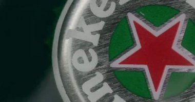 MINSK, BELARUS - 04.10.2020: Heineken şişe kapağının süper makro çekimi yavaş çekim dalgaları, ürün birası, Heineken ticari masa üstü, 4k 60p Prores HQ 10 bit